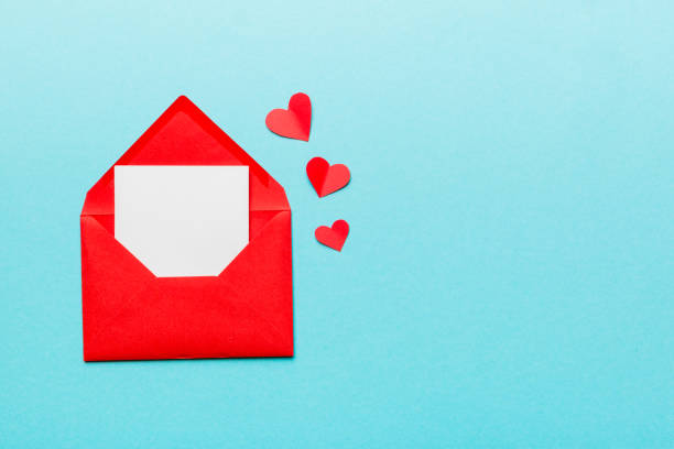 istock Red paper envelope with empty white card and heart on colored background. top view valentines day concept 1358765436