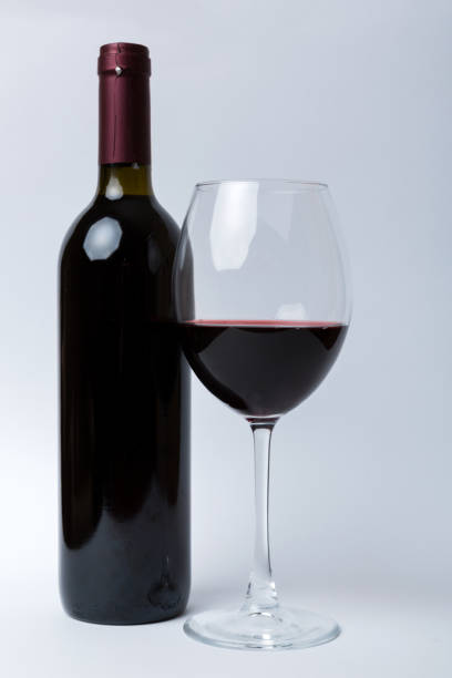 istock Glass of red wine and a bottle on colored table. Flat lay, top view wth copy space 1358765473