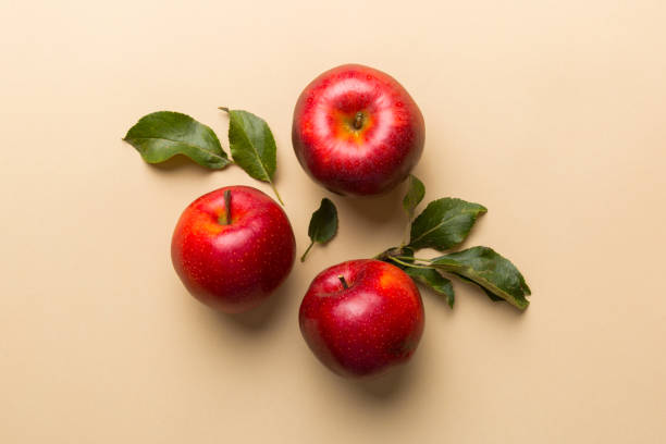 istock Many red apples on colored background, top view. Autumn pattern with fresh apple above view with copy space for design or text 1358765490