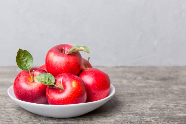 istock juicy red apples in a bowl or plate on the table top view. Copy space 1358765520