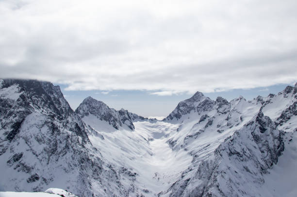 istock Snowy Mountains peaks in the clouds blue sky Caucasus 1358766797