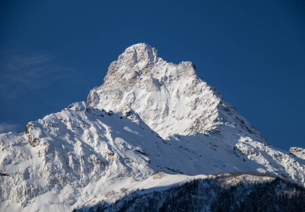 istock Snowy Mountains peaks and clear blue sky 1358767899