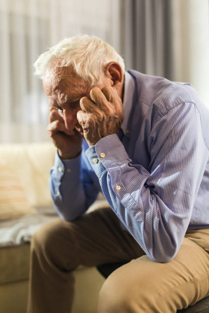 ältere mann zu hause auf dem sofa sitzen, die unter depressionen leiden - senior adult depression dementia alzheimers disease stock-fotos und bilder