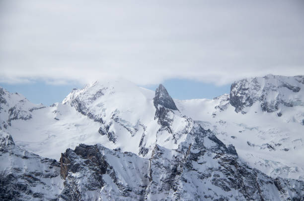 istock Snowy Mountains peaks in the clouds blue sky Caucasus 1358768383