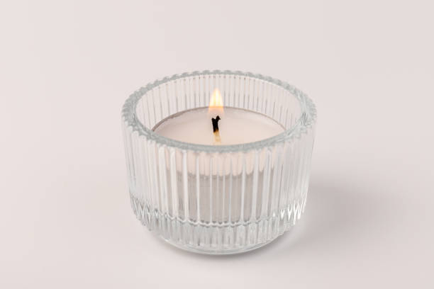 Burning tea candles in a glass holder, isolated on white. Space for text