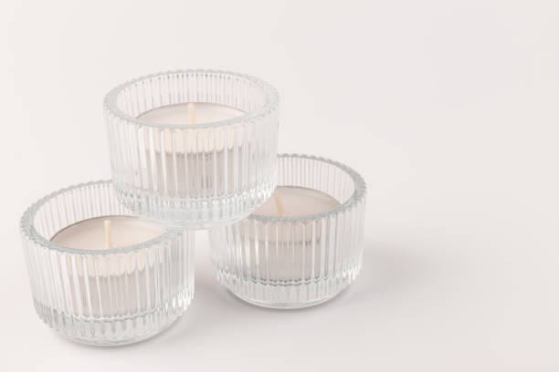 istock Tea candles in a glass candlestick, isolated on white. Space for text 1358771154