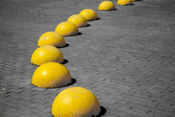 Many yellow concrete hemispheres on the sidewalk