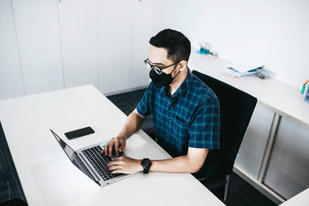 istock asian man in the office working during coronavirus pandemic 1358772585