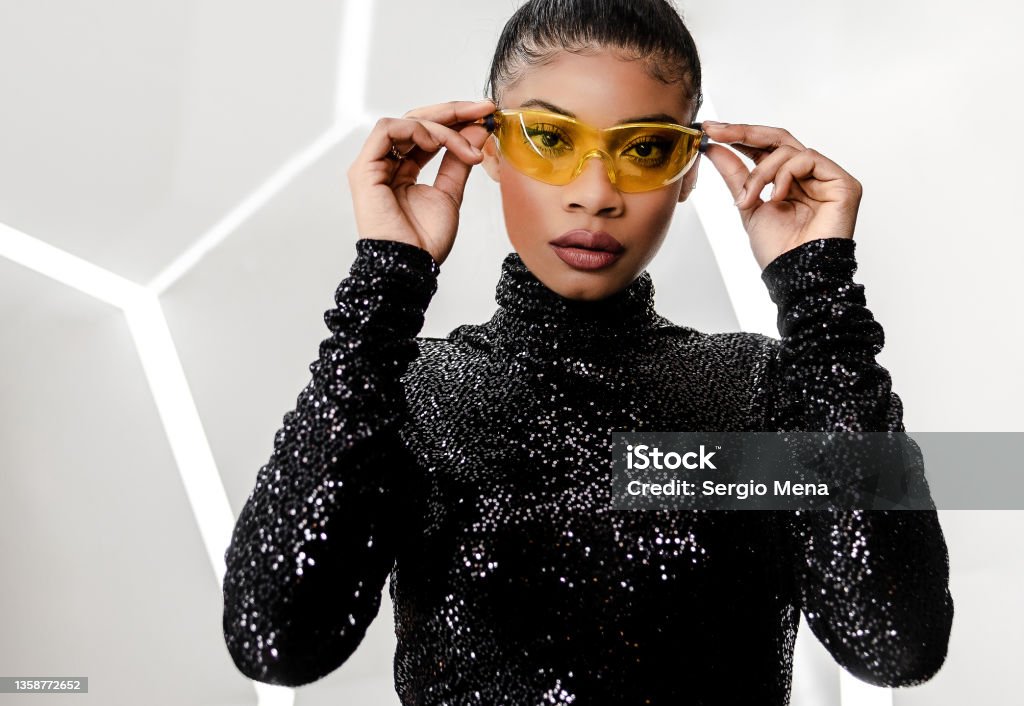Elegant African American woman with her hair pulled back and wearing a shiny black dress Fashion Stock Photo