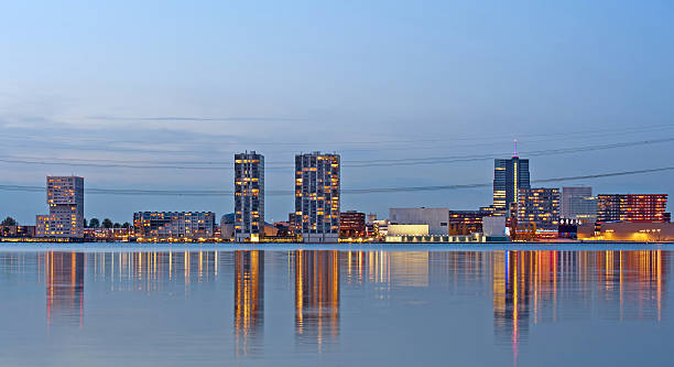 Apartment buildings after sunset, Almere, Holland Skyline of a city along a lake at dusk almere photos stock pictures, royalty-free photos & images