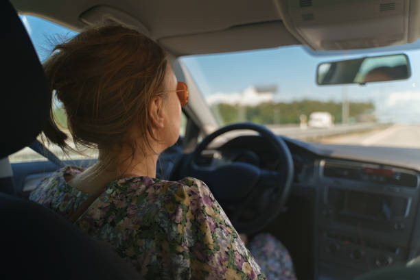 istock Woman driving a car in summer time. 1358773657
