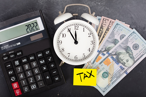 Tax time 2022. Tax and finance concepts. alarm clock, dollar and tax text.