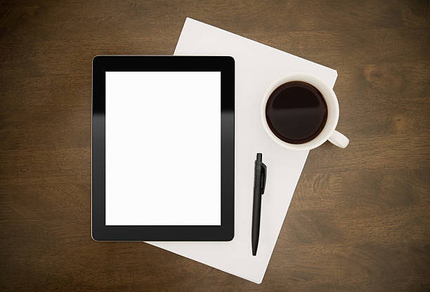 istock Tablet, stationery and coffee sitting on top of a table 135877609