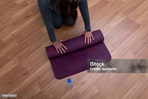 Woman Rolling Yoga Mat Stock Photo - Download Image Now - 40-44 Years, Active Lifestyle, Adult