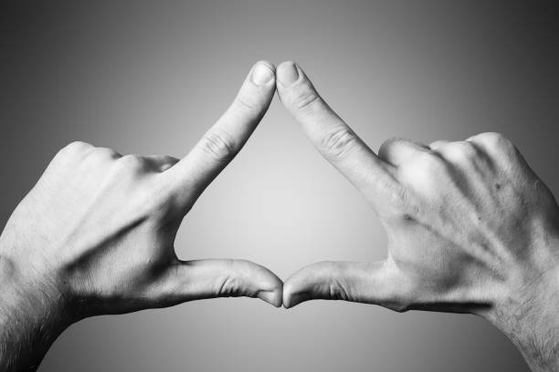 istock Triangle shape made with fingers. Two hands connected together background. 1358779187