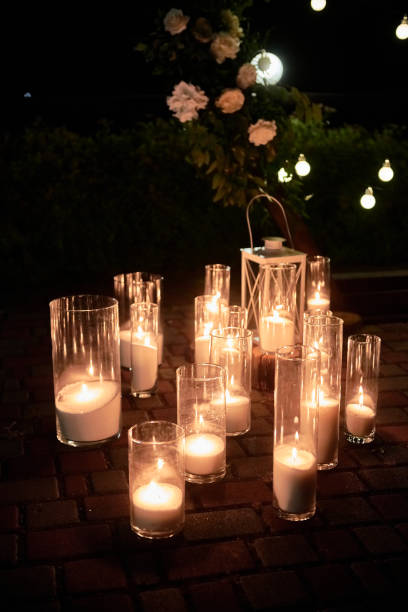 istock Night wedding ceremony decorations with candles in glass vases and bulb lights on tree outdoors, copy space 1358780236