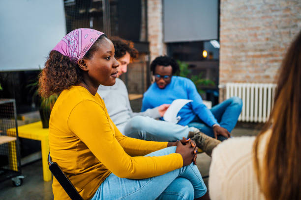 People together on group therapy Young multi ethnic group of people with problems having a discussion while sitting together on group therapy in circle drug addiction tattoos stock pictures, royalty-free photos & images