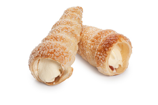 Studio shot of pastry filled with cream and jam, cream horn, cut out against a white background.