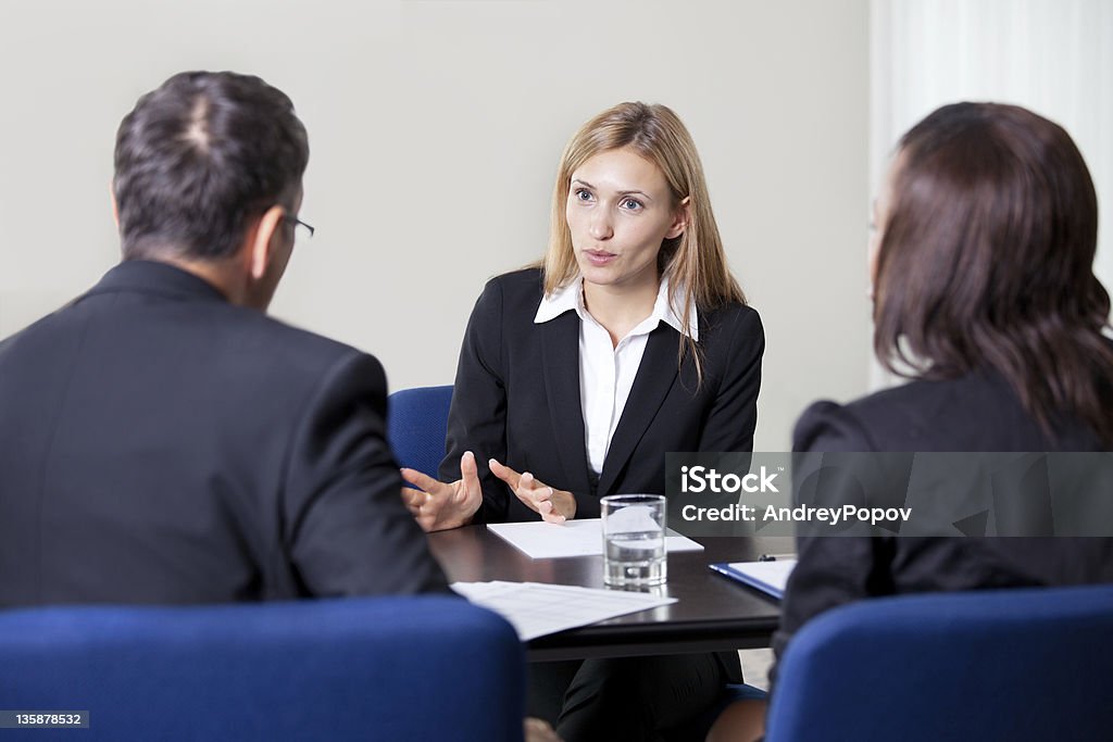 Pretty young woman explaning about her profile Pretty young woman explaning about her profile to business managers at a job interview Adult Stock Photo