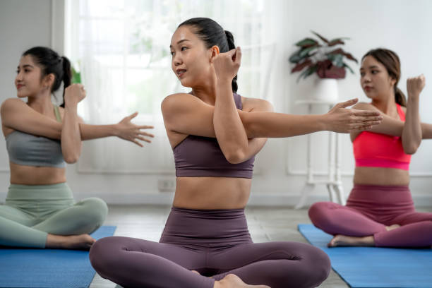 asian female yoga teacher is teaching students in class basic exercises, exercise concepts and wellness - 3144 imagens e fotografias de stock