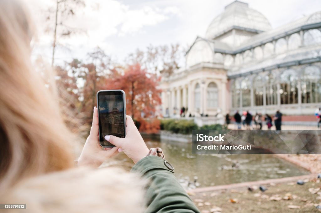 Tourist taking a picture Tourist taking a picture of Palacio de Cristal in Madrid, Spain One Woman Only Stock Photo