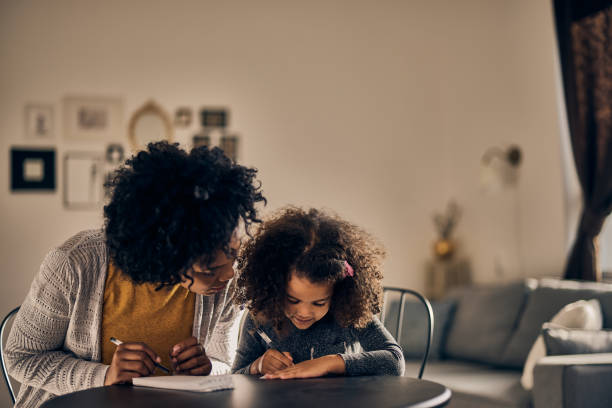 istock Lovely little girl, improving her knowledge with her mother 1358796293
