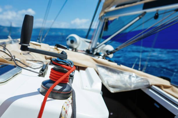 Winch with rope and crank on sailing boat.
