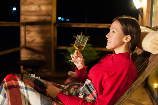 joven hermosa por la noche en la terraza con una copa de vino para año nuevo y navidad - formal garden ornamental garden lighting equipment night fotografías e imágenes de stock