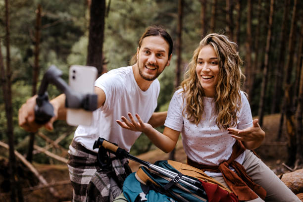 istock Couple recording vlog during hiking using phone 1358798365