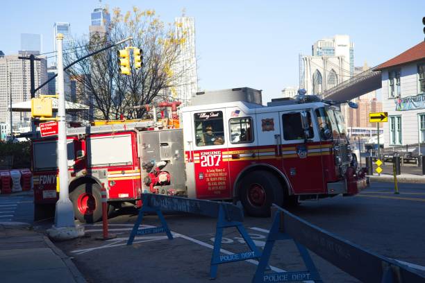 Brooklyn, New York fire engine Brooklyn, NY, USA - Dec 13, 2021: Fire engine turning onto Old Fulton Street along the Brooklyn waterfront with Manhattan skyline in background warren street brooklyn stock pictures, royalty-free photos & images