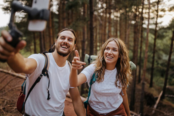 istock Couple recording vlog during hiking using phone 1358798667