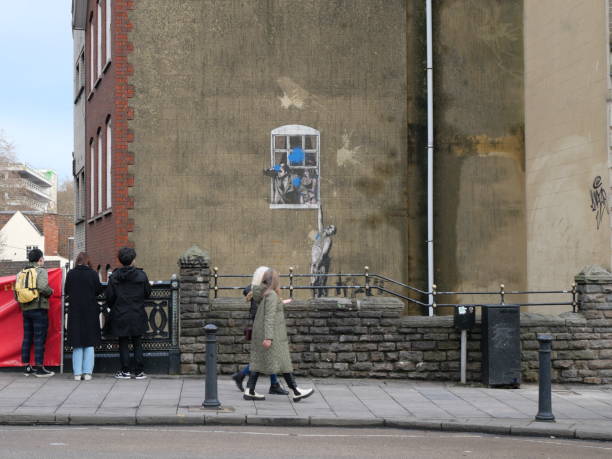 Vandalized Banksy's - Well Hung Lover People walking past Banksy's - Well Hung Lover graffiti 1 Unity St, Bristol BS1 5HH 12-Dec-2021 banksy stock pictures, royalty-free photos & images