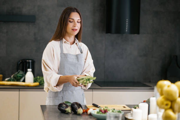 istock Long-haired young woman preparing lunch in the kitchen 1358800424