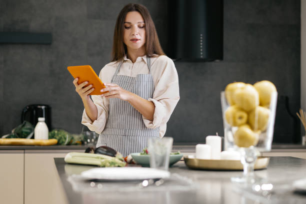 istock Young housewife looking for new cooking ideas on internet 1358800435