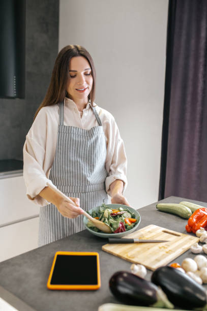 istock Woman cutting vegetables on a cutting board 1358800498