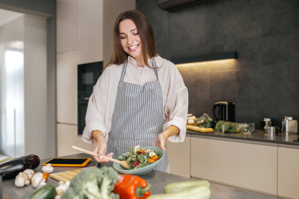 istock Cute positive woman in the kitchen 1358800505