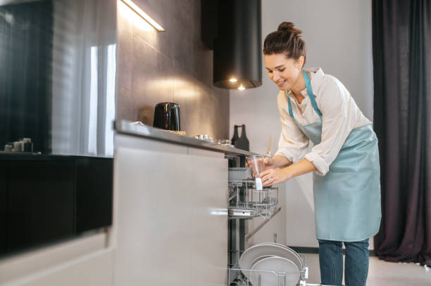 istock Young woman in the kitchen looking busy while washing the plates 1358800577