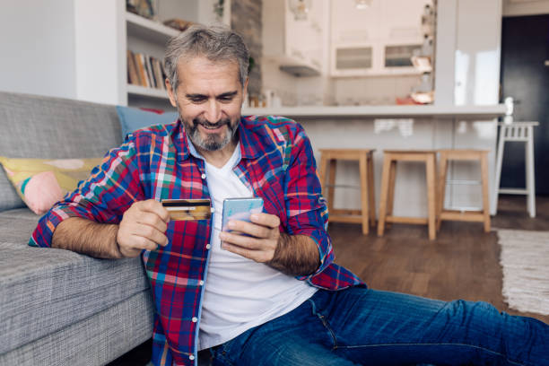 istock Happy mature man shopping online from home 1358800719