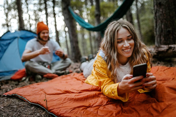 istock Women lying on blanket during hiking using phone 1358800894
