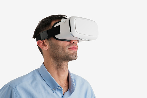 Young man using virtual reality glass on white background
