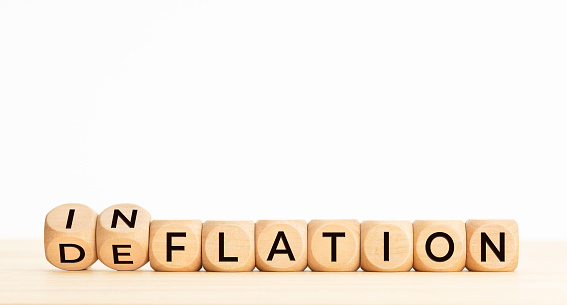 Inflation or deflation word in wooden blocks on table. Copy space
