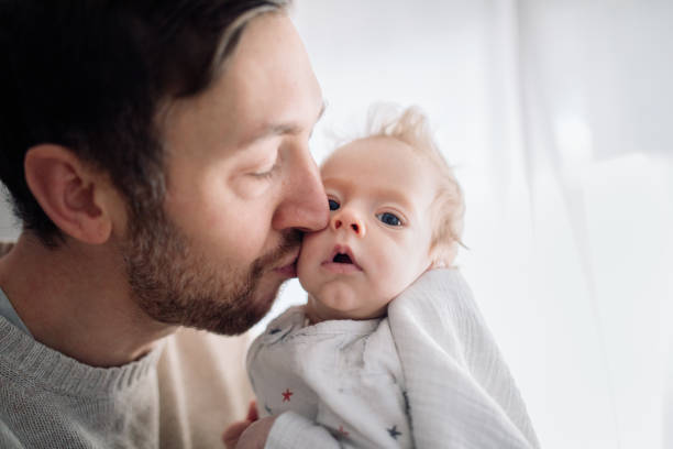 istock Father Kissing Infant Son 1358807611