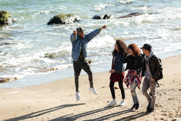 istock Happy african friends walking outdoors at beach 1358809811