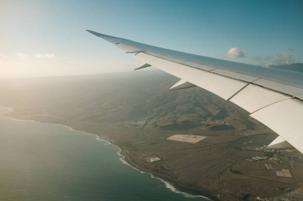 istock Airplane flying over a coastal destination 1358812253