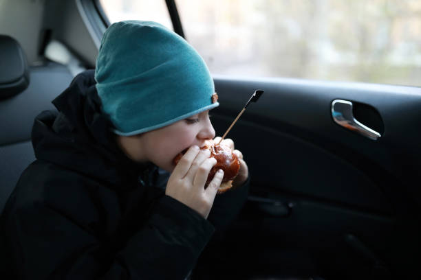 istock Child eating burger in car 1358812546