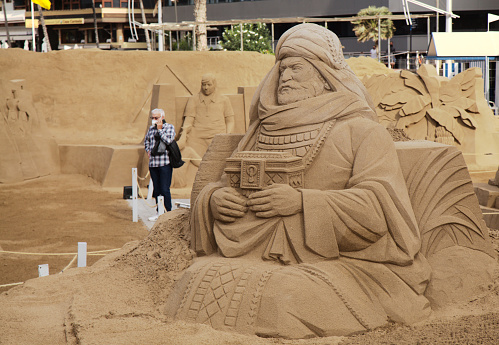 Las Palmas de Gran Canaria, Spain - December 13:  Visitors admire Belen de Arena, Nativity scenes made \nof sand, on Las Canteras town beach, December 13, 2021 in Las Palmas de Gran Canaria, Spain