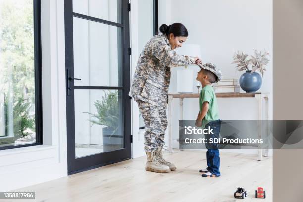 Preschool boy greets soldier mom at door