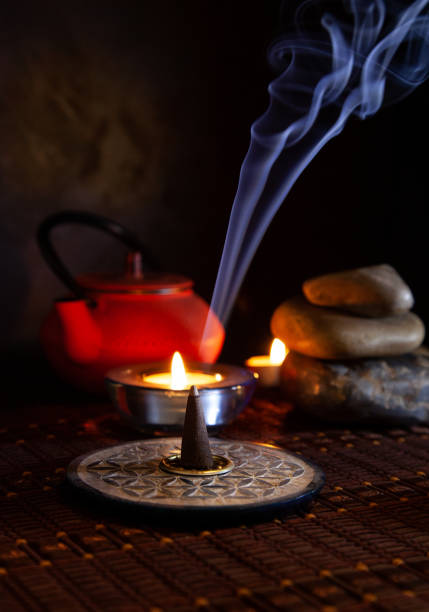 istock Aromatic incense cone lit next to an oriental iron teapot 1358818437