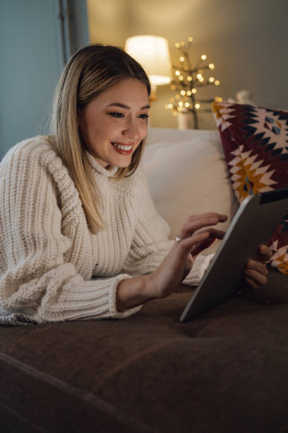 istock Young woman uses a digital tablet at home 1358824411