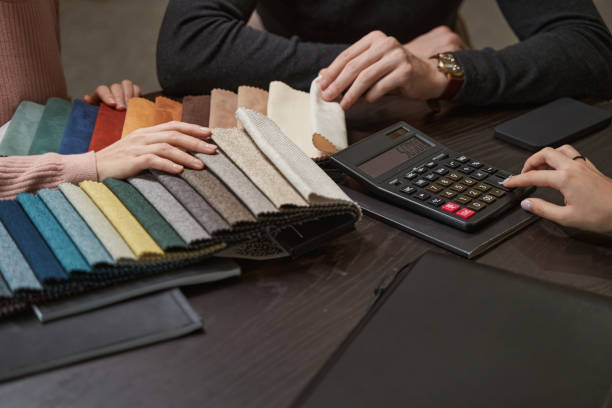 istock Two Caucasian customers examining new fabric swatches 1358824417